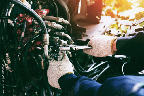 Close up view of hydraulic pipes of heavy industry machine. Low key. Hydraulic maintenance concept.