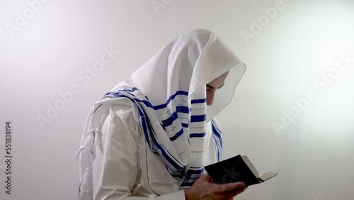 Religious jew in a tallit prays with a siddur in his hand. Judaism and jewish traditions (139) photo