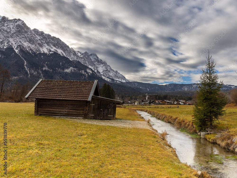Landschaft in Oberbayern mit Bach,Bergen und Wolkenhimmel
