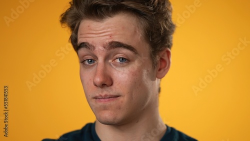 Closeup portrait of smiling happy young hipster man 20s isolated on solid yellow background in studio