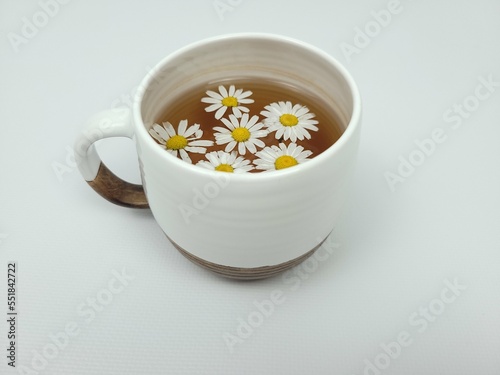 Chamomile tea in a white clay cup on a light background