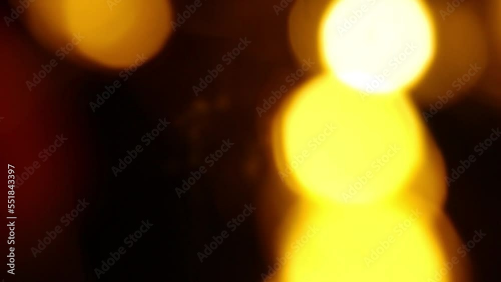 Yellow bokeh effect in darkness. Christmas lights. You can use it for video transitions. Copy space for text.	
