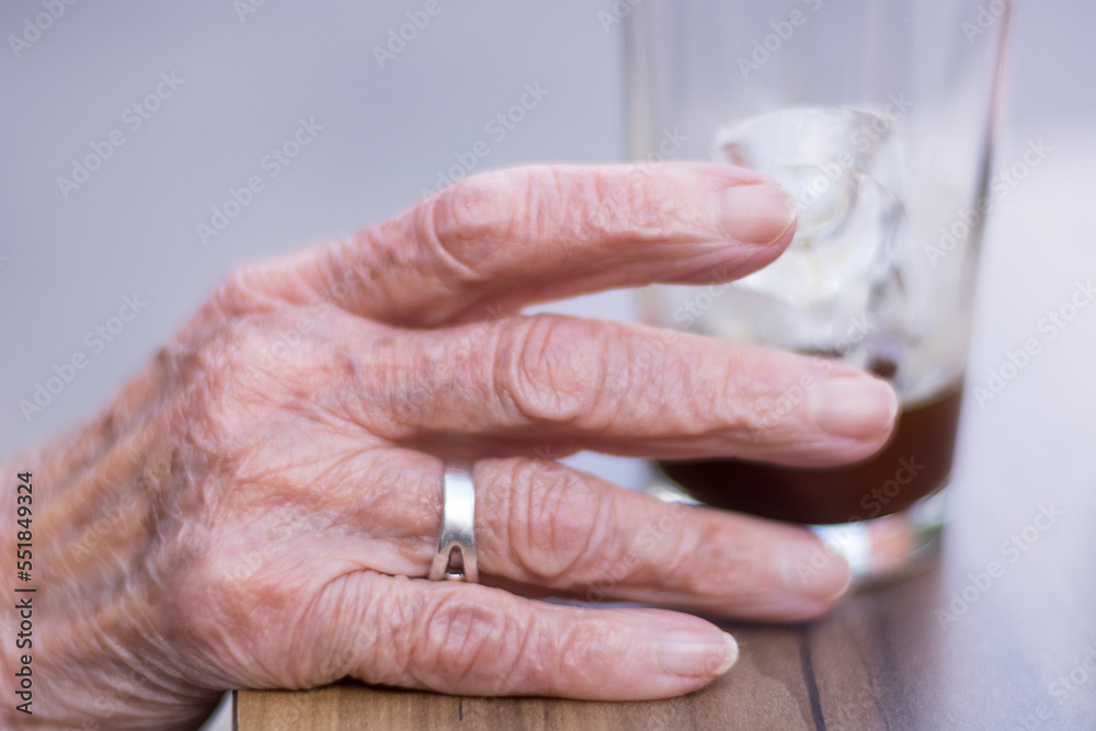 Naklejka premium Old person holding a glass of water