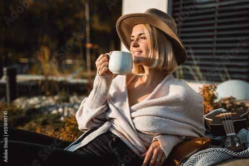 Obraz na płótnie Beautiful woman in cowboy hat drinking coffee on patio in front of her house w salonie