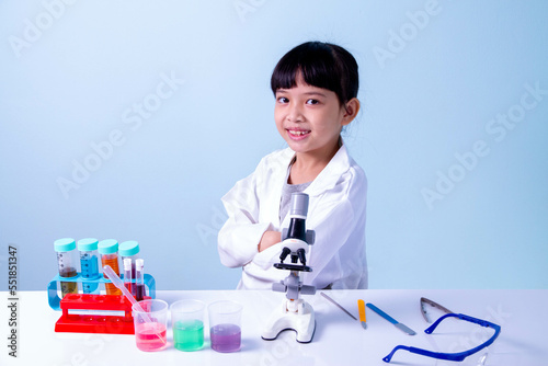Little asian cute girl 7 years old learning in science lab with equipment. Young scientist.
