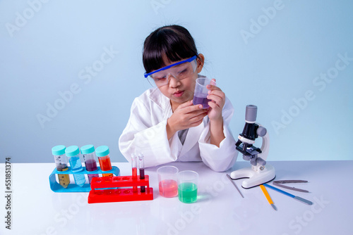 Little asian cute girl learning a scientist in biology lab with equipment and looking at liquid chemicals in tube. Learning and education of kid.