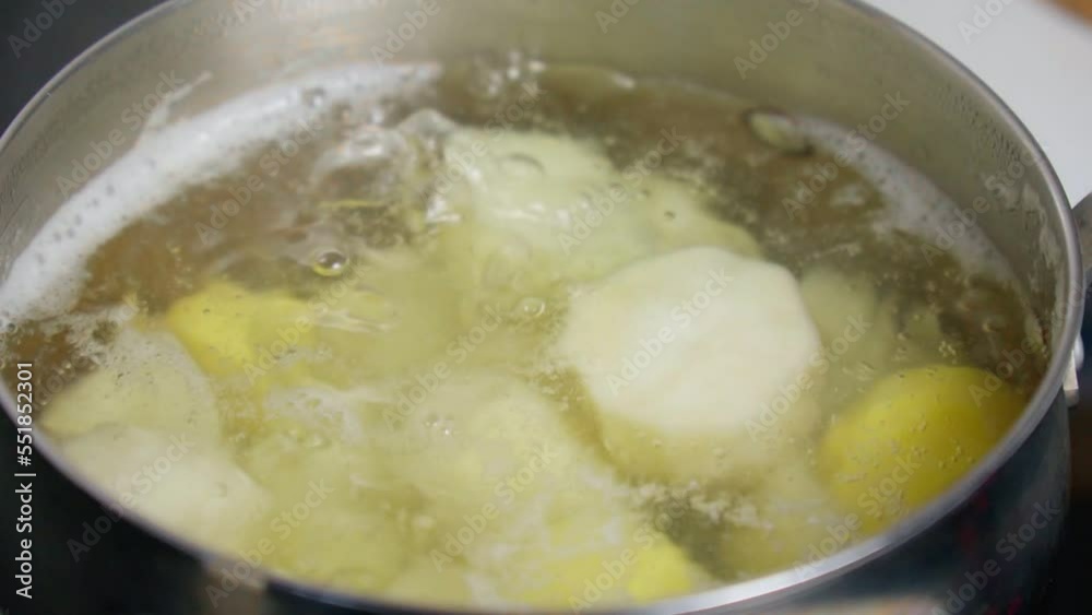 Cooking potatoes in hot water close up. Home cooking. Selective focus. Slow motion Cooking potatoes in hot water close up. Home cooking. Selective focus. Slow motion
