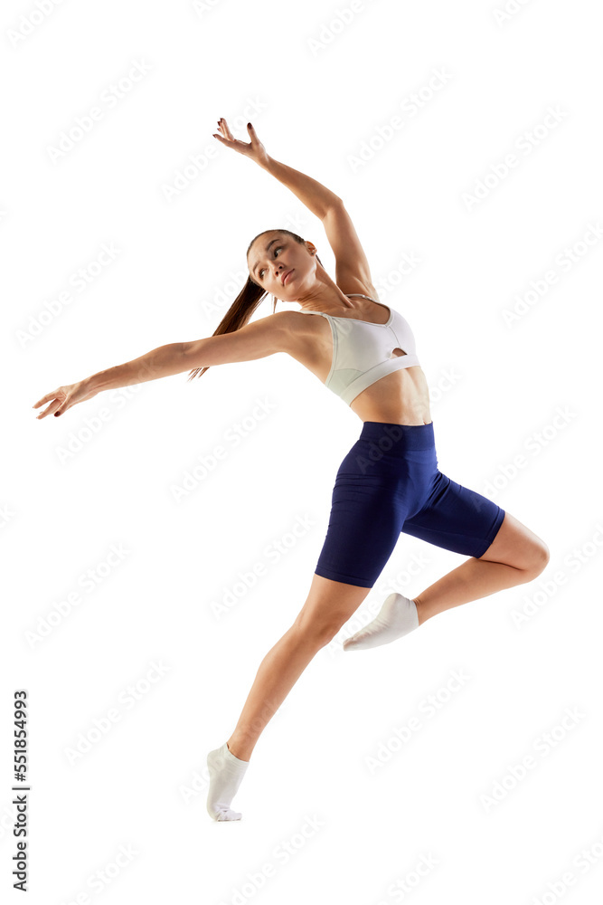 Portrait of young sportive woman training, doing warming up exercises, jumping isolated over white background. Concept of sport, fitness, health Portrait of young sportive woman training, doing warming up exercises, jumping isolated over white background. Concept of sport, fitness, health