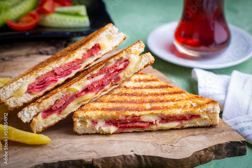 Turkish toast, mixed toast with cheddar cheese, sausage and ham, with fried potatoes (Turkish name; Karisik tost)