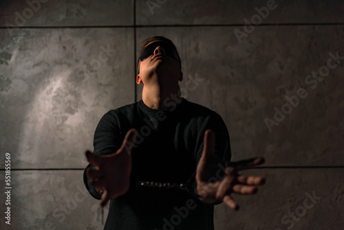 man in mask and handcuffs in dark out of focus