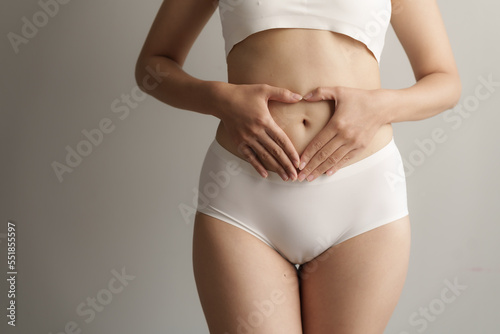 Close up asian woman cropped shot with white panties on grey background, vagina healthy concept.