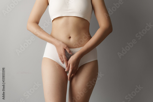 Close up asian woman cropped shot with white panties on grey background, vagina healthy concept.