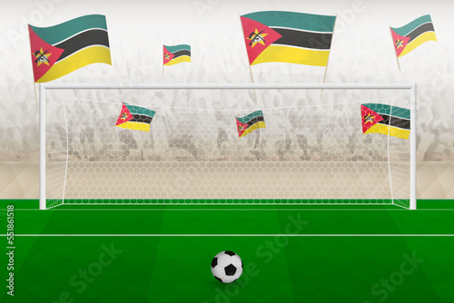 Mozambique football team fans with flags of Mozambique cheering on stadium, penalty kick concept in a soccer match.