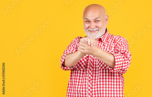 glad senior man or grandfather in checkered shirt on yellow background