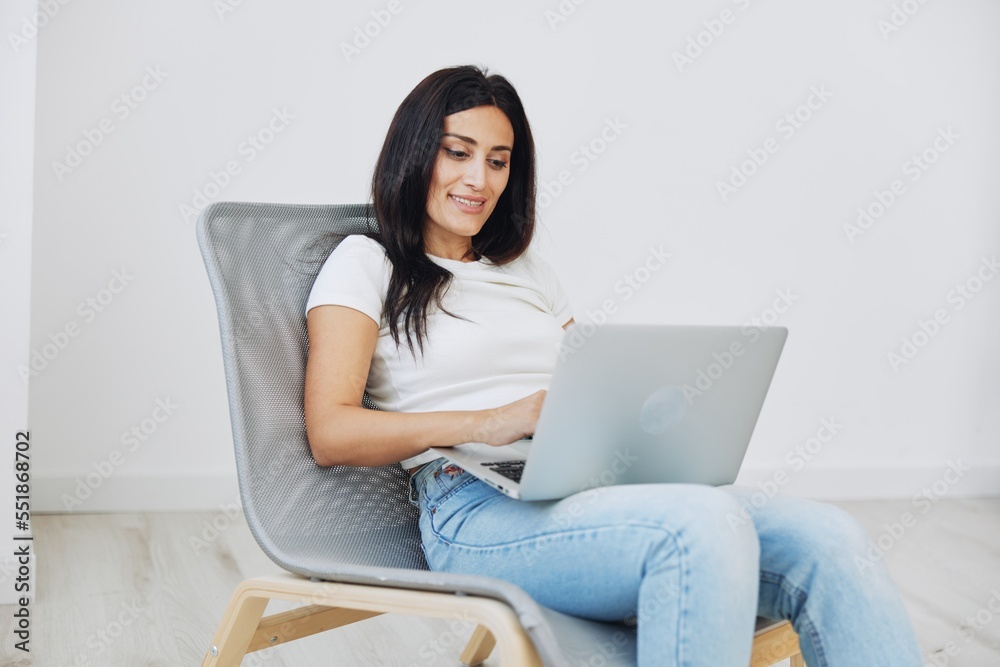 Woman relaxing at home sitting in a chair with a laptop, lifestyle home mood. Mockup, free copy space Woman relaxing at home sitting in a chair with a laptop, lifestyle home mood. Mockup, free copy space
