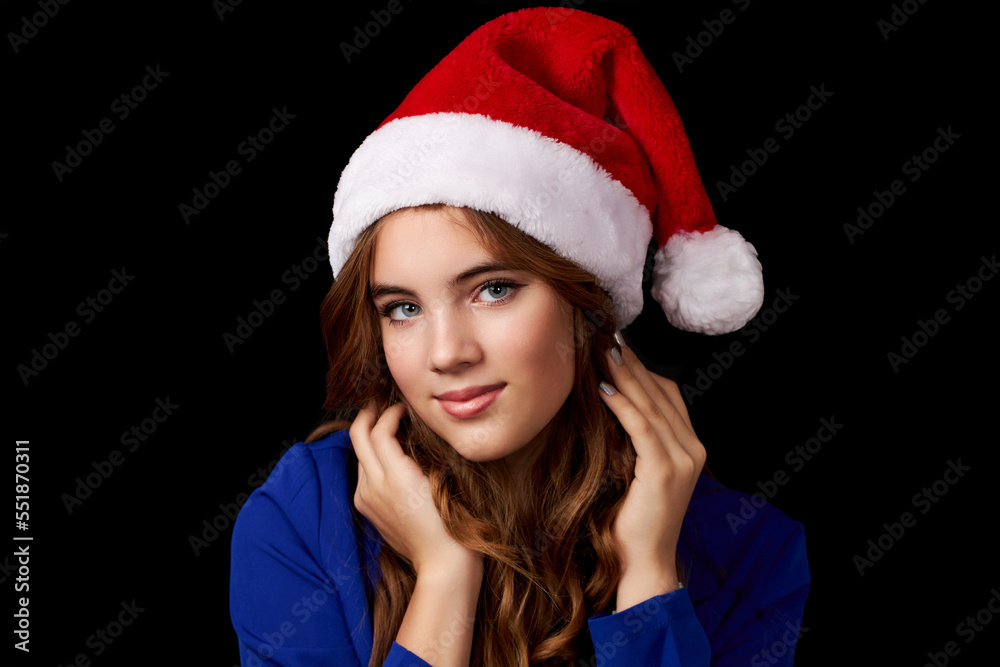 caucasian girl with long hair in blue dress wearing santa claus hat isolated on black background caucasian girl with long hair in blue dress wearing santa claus hat isolated on black background