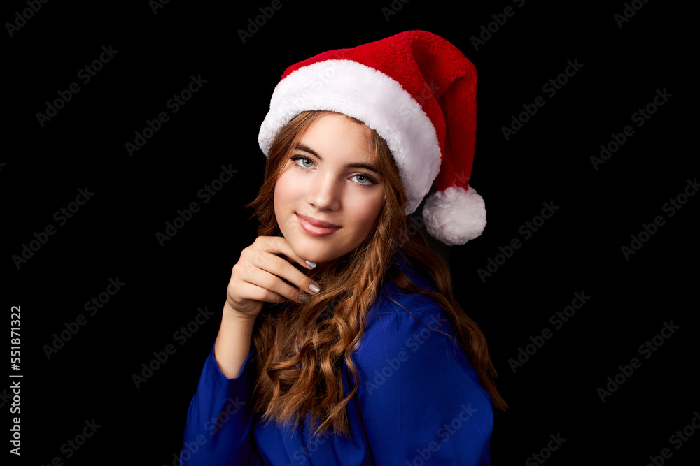 caucasian girl with long hair in blue dress wearing santa claus hat isolated on black background caucasian girl with long hair in blue dress wearing santa claus hat isolated on black background