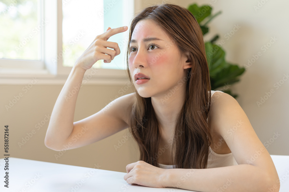 Dermatology, puberty asian young woman, girl looking into mirror, allergy presenting an allergic reaction from cosmetic, red spot or rash on face. Beauty care from skin problem by medical treatment. Dermatology, puberty asian young woman, girl looking into mirror, allergy presenting an allergic reaction from cosmetic, red spot or rash on face. Beauty care from skin problem by medical treatment.