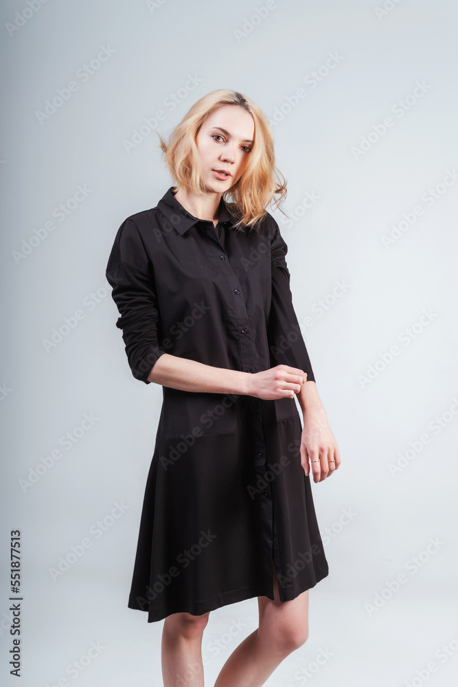 Girl In A Black Dress On A White Background The Girl Fastens The Girl In A Black Dress On A White Background The Girl Fastens The