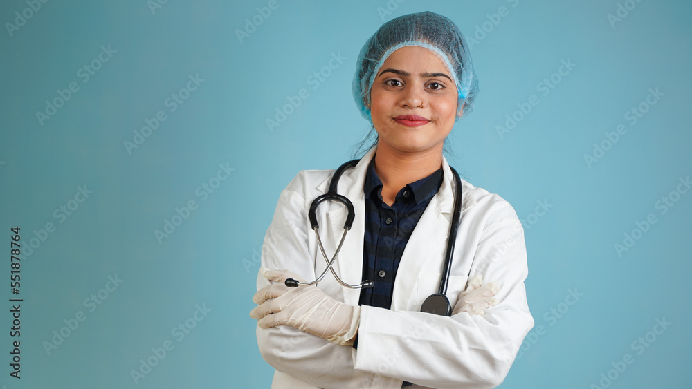 Portrait of a young female doctor wearing apron and stethoscope, Cheerful Asian Indian woman doctor isolated over blue studio background Portrait of a young female doctor wearing apron and stethoscope, Cheerful Asian Indian woman doctor isolated over blue studio background