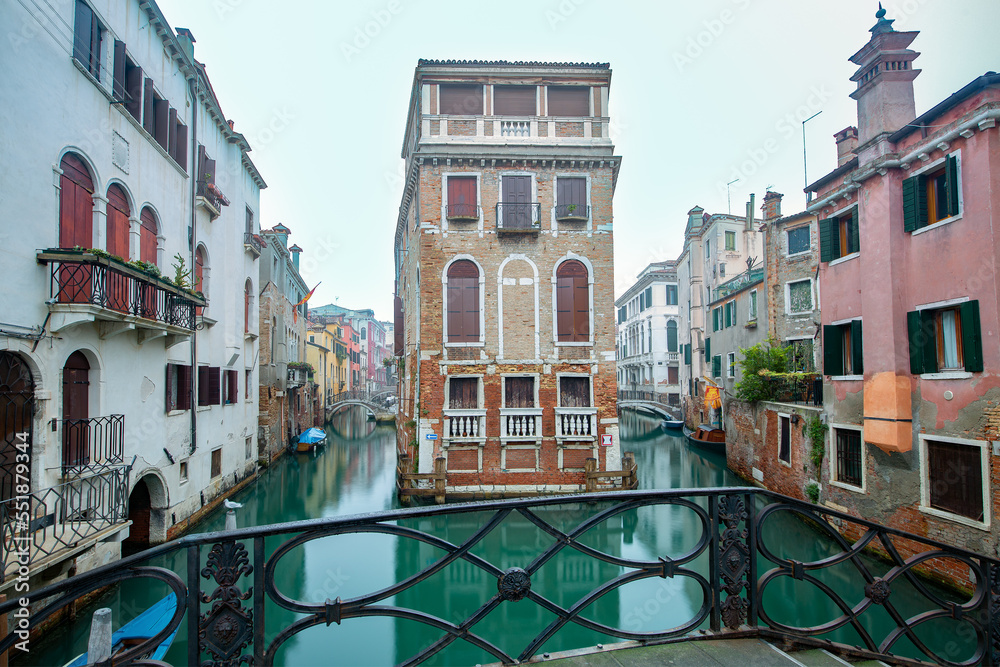 Typical Venetian canal with bridge in early morning, Venice, Italy