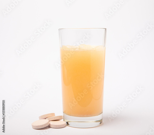 Obraz na plátně Vitamin C effervescent tablets with orange flavor drops and dissolves in a glass of water isolated on a white background