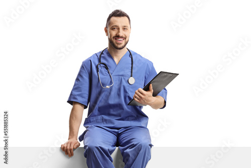 Helath care worker in a blue uniform sitting on a blank panel
