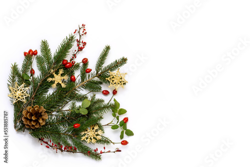 Natural floral christmas corner - rustic decoration of  green spruce, barberry twigs and wild rose fruits with straw stars, flat lay, copy space