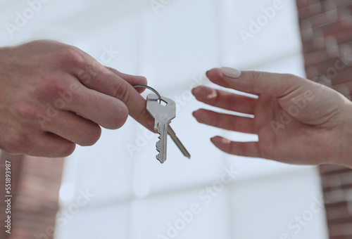 Cropped image of estate agent giving house keys to man in office