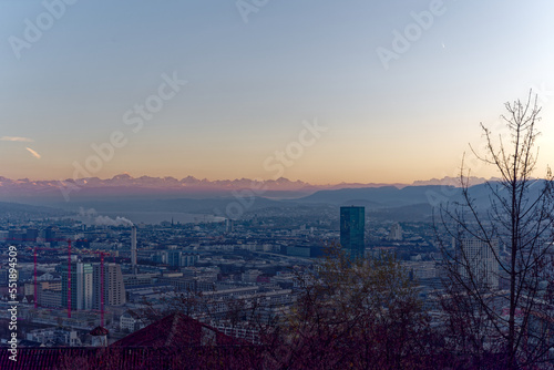 Aerial view over City of Zürich with Swiss Alps in the background on a sunny autumn evening. Photo taken December 6th, 2022, Zurich, Switzerland.