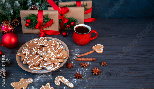 Traditional homemade gingerbread cookies and a cup of coffee among the Christmas decor. Christmas mood, holiday atmosphere.