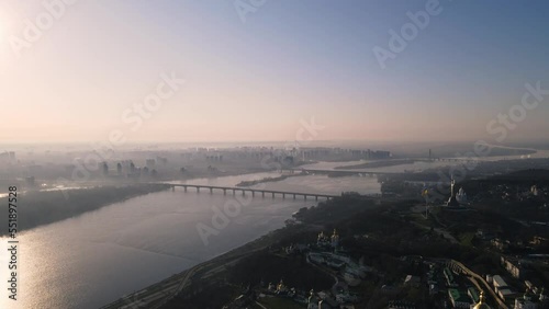 Kyiv, Ukraine - April, 2021: Morning aerial view on foggy city with traffic and bridge on Dniepro river with Mother Motherland and ukrainian flag 4k photo