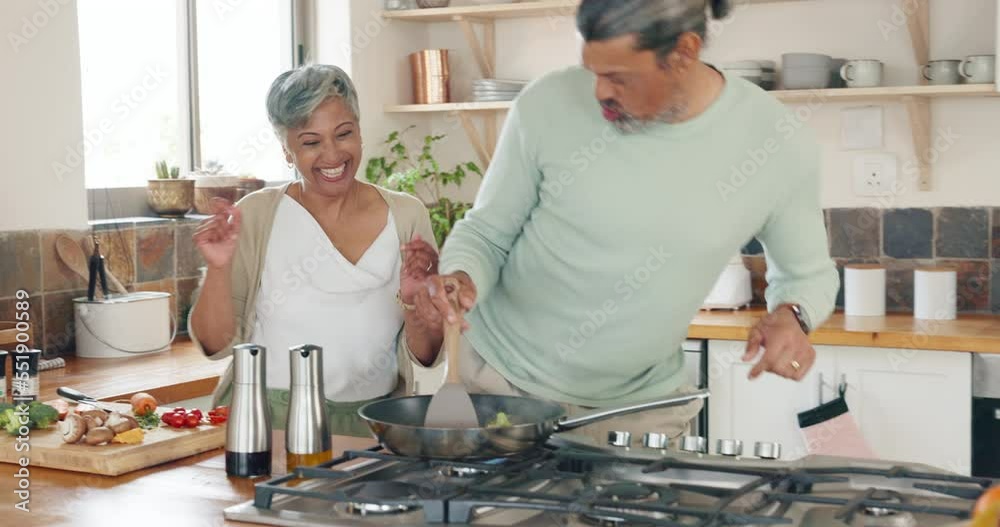 Mature couple, cooking and dancing in kitchen for love, care and funny time together in family home. Happy man, woman and partners dance, singing and prepare fresh dinner, lunch and food in house