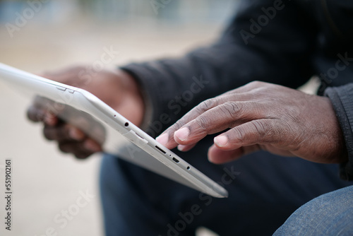 African american man uses tablet computer. Mans hands holds a tablet pc