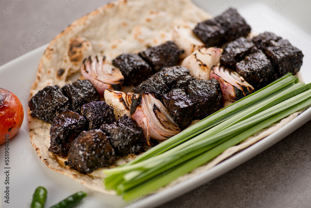 Beef Rikak Beef tikka boti seekh kabab with onion and bread served in dish ...