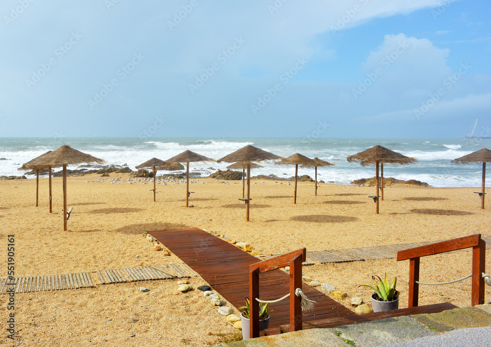 Portugal empty beach with umbrellas at the atlantic ocean Portugal empty beach with umbrellas at the atlantic ocean