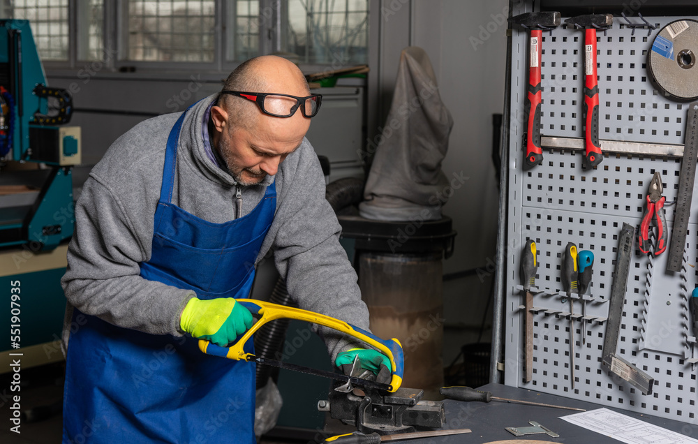 Worker is sawing in mechanical plant Worker is sawing in mechanical plant