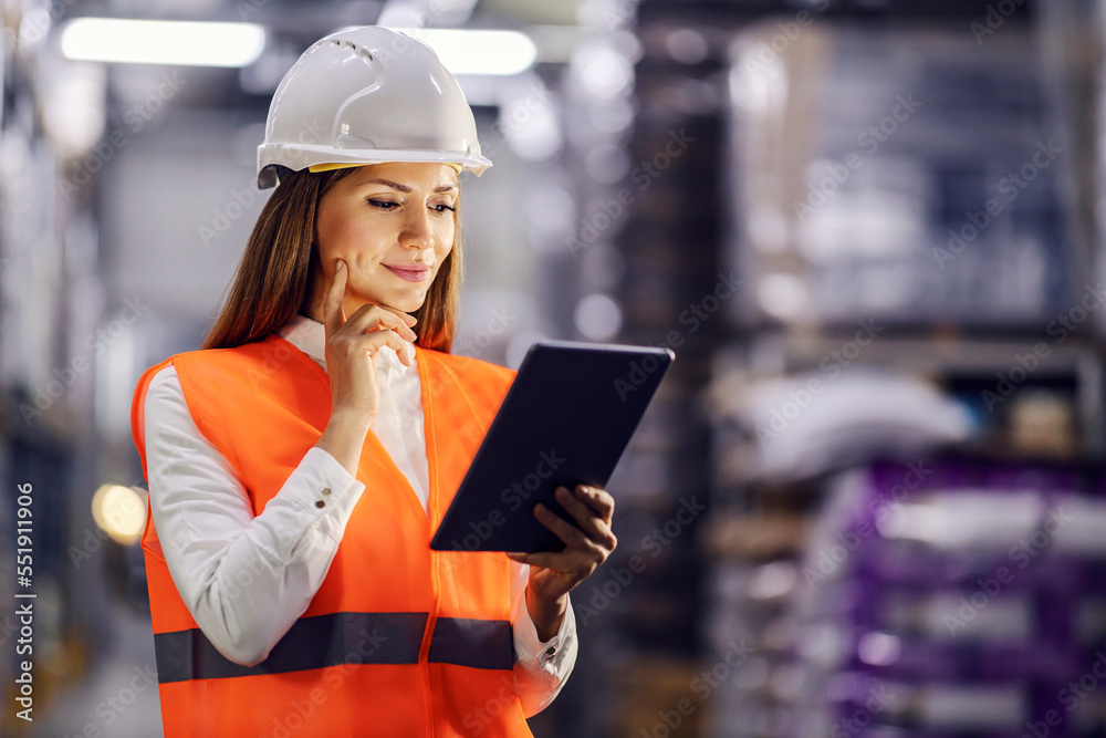 A storage manager is standing in facility and carefully tracking shipment. A storage manager is standing in facility and carefully tracking shipment.