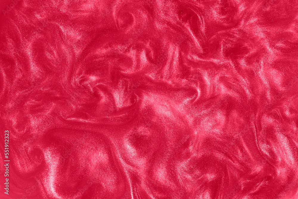 Red paint background. Motion of the pink shiny liquid. Color of the year 2023 Viva Magenta. Waves on a glittering liquid. Red paint background. Motion of the pink shiny liquid. Color of the year 2023 Viva Magenta. Waves on a glittering liquid.