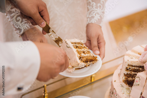 the newlyweds cut off a piece of wedding cake the bride and groom cut off a piece of cake and put it on a plate