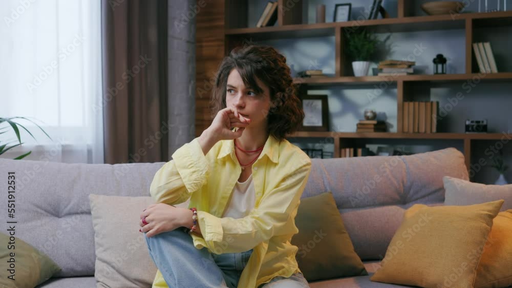Tired curly girl falls down while sitting on the couch feeling apathy. Feeling depressed, lack of motivation, sadness, boredom. Tired curly girl falls down while sitting on the couch feeling apathy. Feeling depressed, lack of motivation, sadness, boredom.