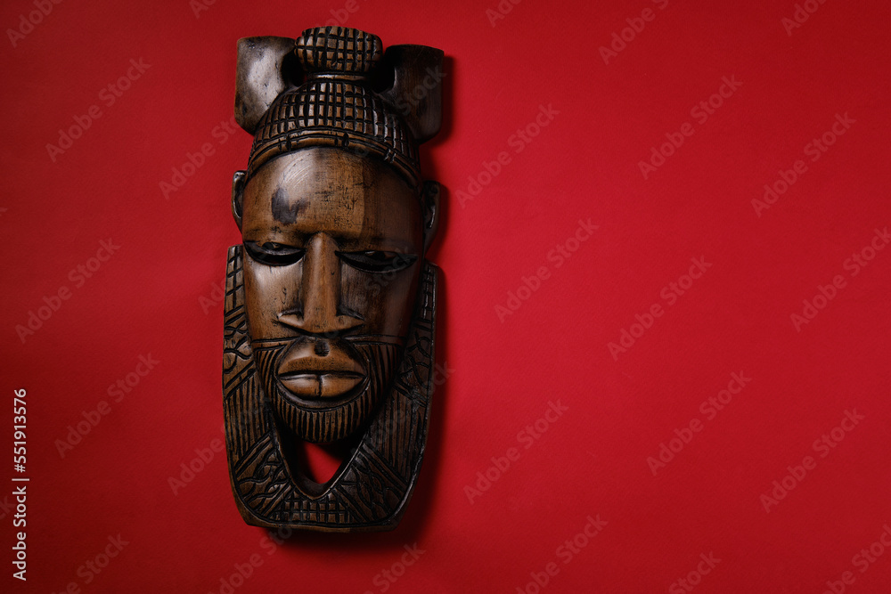 Antique African mask on a red background, top view, space for an ...