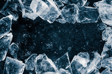 Ice cubes crush on black background. Chill backdrop. Frame border, made of ice.