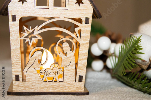 Nativity scene on a hill in the snow. Joseph of Nazareth lights the lantern and Mary tends to her baby, Jesus photo