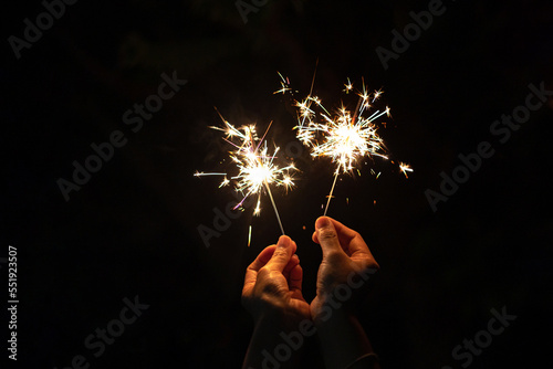 hand holding sparkler isolated on black background symbolizes the new year and celebration