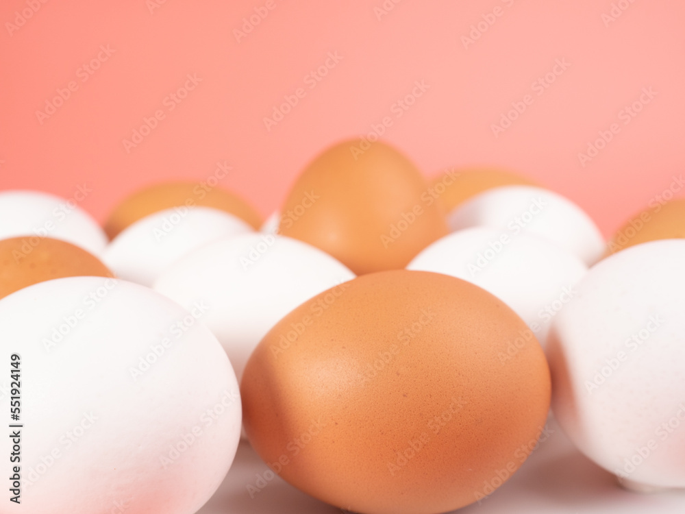 Chicken eggs on a pink background. White and brown egg on a pink background. Chicken eggs on a pink background. White and brown egg on a pink background.