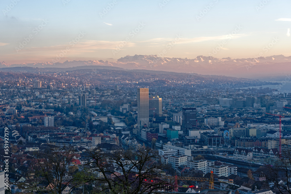 Aerial view over City of Zürich with Limmat River and Swiss Alps in the background on a sunny autumn evening. Photo taken December 6th, 2022, Zurich, Switzerland.