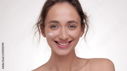 Slow motion portrait woman uses creams. Concept for fresh moisturized skin. Beautiful close up cosmetic face happy healthy model. Young female take care of her skin. Beautiful girl smiling to camera.