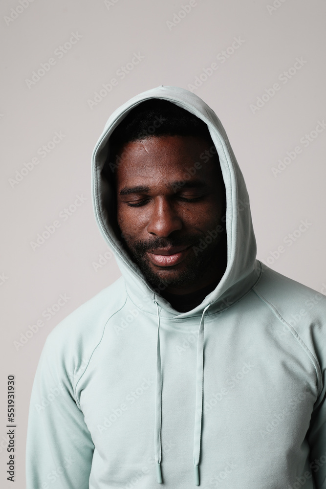 Optimistic young man wearing a hood and posing indoor. Vertical mock-up. Optimistic young man wearing a hood and posing indoor. Vertical mock-up.