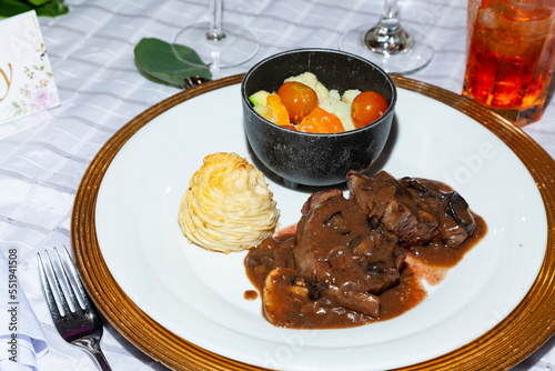 Tasty sirloin medallions bathed in mushroom sauce, steamed vegetables and mashed potatoes photo